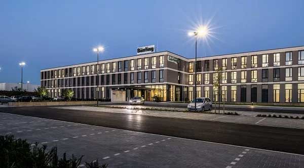 Verwaltungsgebäude der Bünting Unternehmensgruppe bei Abenddämmerung mit moderner Architektur und beleuchtetem Eingangsbereich als Referenzstandort