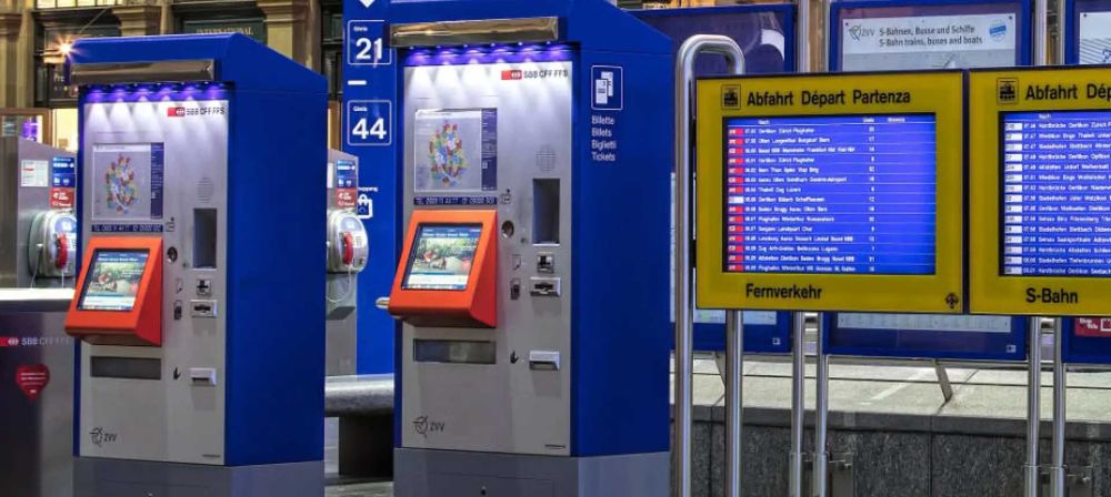 Fahrkartenautomaten und digitale Anzeigetafel in einem Bahnhof als Symbol für öffentlichen Verkehr, Ticketing und Fahrgastinformation