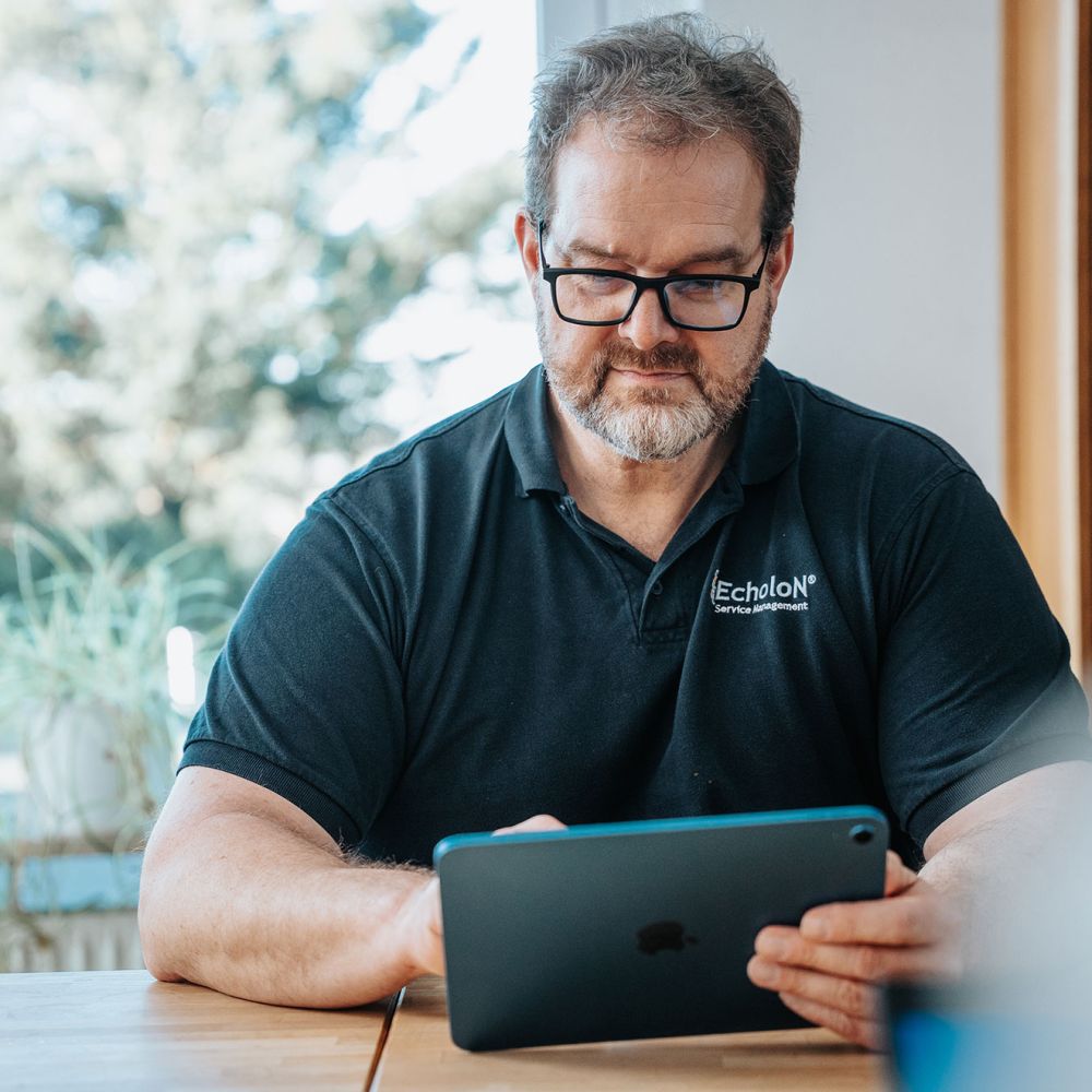 Mitarbeiter von mIT solutions nutzt ein Tablet im Büro und arbeitet konzentriert an digitalen Prozessen und Softwarelösungen