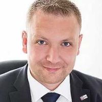 Porträt eines Mannes im Anzug, der direkt in die Kamera blickt und einen seriösen und professionellen Eindruck vermittelt
