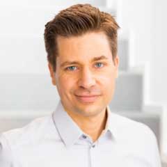 Porträt eines Mannes im Hemd, der freundlich in die Kamera blickt und einen professionellen Eindruck vermittelt